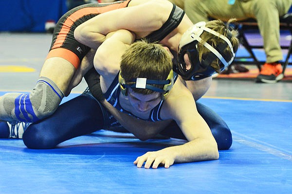 Helias' Zack Carr attempts to free his arm while wrestling Platte County's Austin Kincaid in the first round of the Class 3 state championships Thursday at Mizzou Arena.