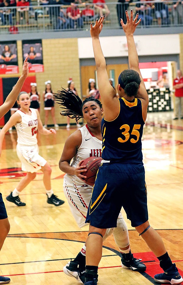 Jefferson City's Ileah Chambly works past Battle's Kendra Mackey during Thursday night's game at Fleming Fieldhouse.