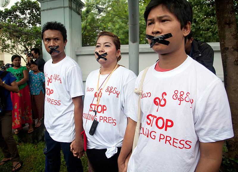 FILE - In this July 12, 2014, file photo, Myanmar journalist Thet Oo Maung, known as Wa Lone, right, stands with other journalists with their mouths taped, symbolizing the government's crackdown on media, in Yangon, Myanmar. Under Aung San Suu Kyi, Myanmar has aggressively pursued legal charges against dozens of journalists, along with other attempts to suppress and discredit the media. (AP Photo/Khin Maung Win, File)