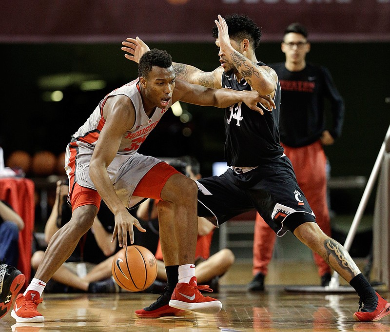 Houston forward Fabian White Jr. (35) looks for a way around Cincinnati guard Jarron Cumberland (34) during the first half of an NCAA college basketball game Thursday, Feb. 15, 2018, in Houston. (AP Photo/Michael Wyke)