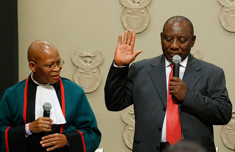 Cyril Ramaphosa is sworn in as South African President by Chief Justice Mogoeng Mogoeng, left, in Cape Town, South Africa Thursday Feb. 15, 2018. Ramaphosa on Thursday was elected unopposed as South Africa's new president by ruling party legislators after the Wednesday resignation of Jacob Zuma. (Mike Hutchings / Pool via AP)