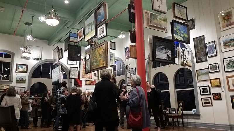 Visitors at the grand opening of the 1894 City Market Art Gallery mingle and examine the art on display Friday night at its location at 105 Olive St. in downtown Texarkana. (Photo by Kate Stow)