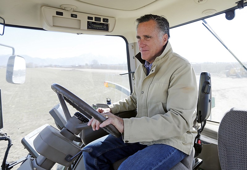 In this Feb. 16, 2018, photo, former Republican presidential candidate Mitt Romney sits behind the wheel of a tractor during a tour of Gibson's Green Acres Dairy in Ogden, Utah. If Romney becomes Utah's next senator, many Republicans are looking to the him to take up John McCain's mantle as an elder statesman, willing to take on Donald Trump and serve as a political and moral counterweight to a president they see as divisive and undignified. (AP Photo/Rick Bowmer)`