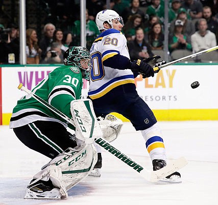 Stars goalie Ben Bishop defends against an airborne puck in front of the net under pressure from Alexander Steen of the Blues during Friday night's game in Dallas.