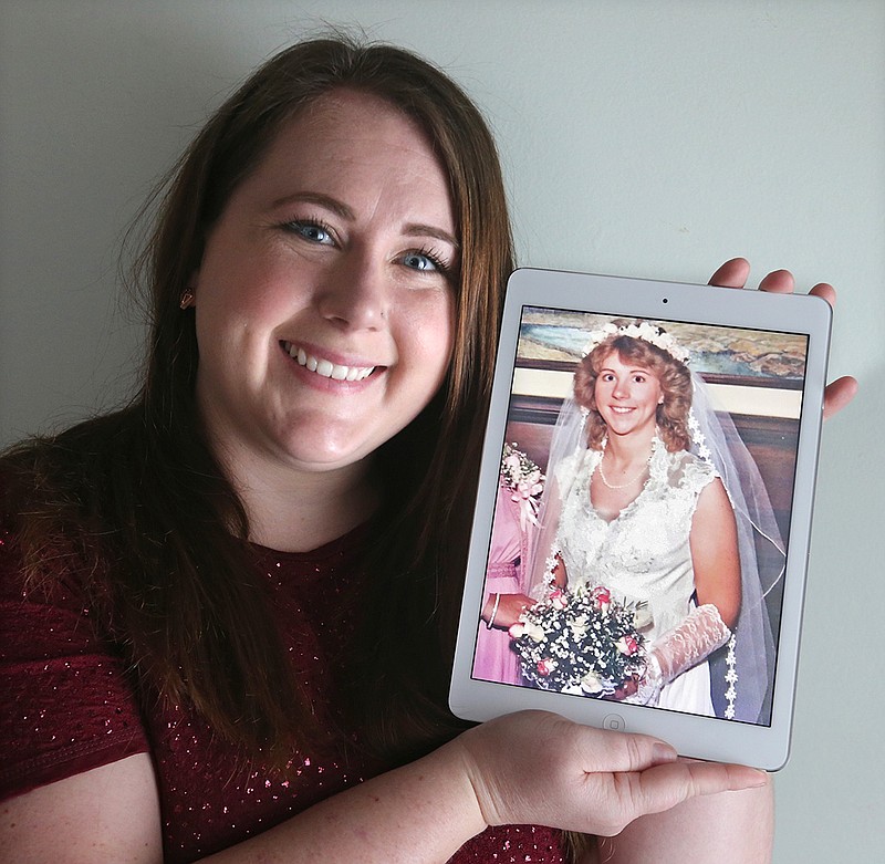 Ame Bartlebaugh holds a 1980 photo of her mother in her wedding dress in Willowick, Ohio. Bartlebaugh posted pictures on Facebook of a lacy wedding dress, a veil and a hoop skirt with an explanation of a1985 mix-up with the now-defunct, dry cleaner who gave her the dress, thinking it was her mothers. Bartlebaugh found the rightful owner of the dress but is still searching for her mothers dress that she hopes to wear at her wedding in December 2019. (Phil Masturzo/Akron Beacon Journal via AP)