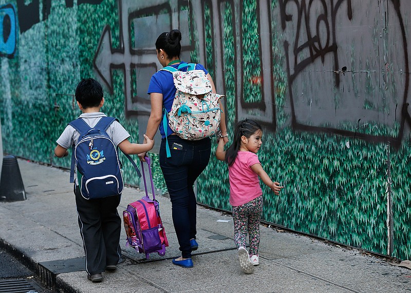 A mother walks with her children in the aftermath of a 7.2-magnitude earthquake that shook Mexico City, Friday, Feb. 16, 2018. A powerful earthquake has shaken south and central Mexico, causing people to flee buildings and office towers in the country's capital, and setting off quake alert systems. (AP Photo/Marco Ugarte)