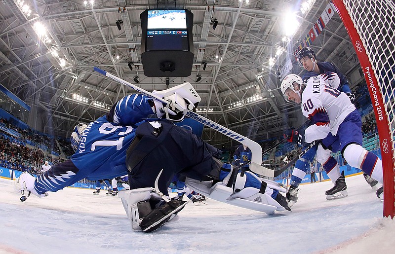 Goalie Mikko Koskinen (19), of Finland, dives for the puck shot by Ken Andre Olimb (40), of Norway, during the first period of the preliminary round of the men's hockey game at the 2018 Winter Olympics in Gangneung, South Korea, Friday, Feb. 16, 2018. (Bruce Bennett/Pool Photo via AP)