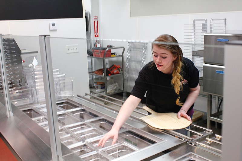 Danna Nolen, general manager of Crave Pizza, prepares equipment for Thursday's opening.