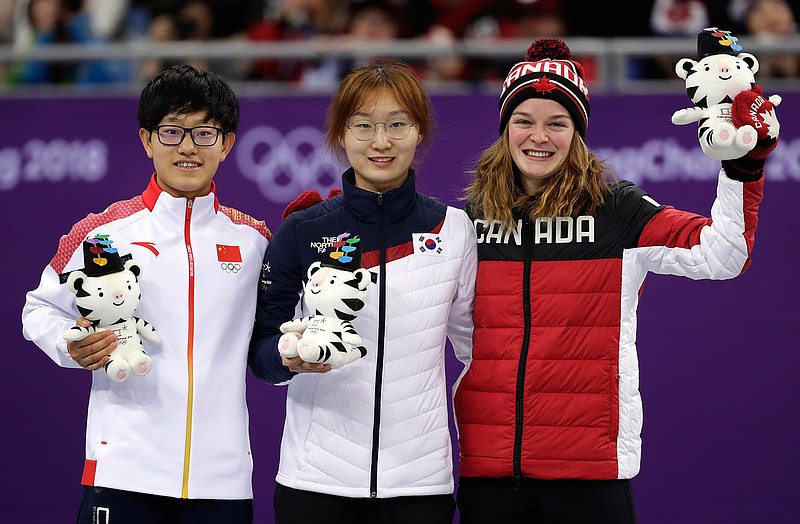 Gold medalist Choi Minjeong, centre, of South Korea stands with silver medalist Li Jinyu of China and bronze medalist Kim Boutin, right, of Canada during the victory ceremony for the women's 1500 meters short track speedskating final in the Gangneung Ice Arena at the 2018 Winter Olympics in Gangneung, South Korea, Saturday, Feb. 17, 2018. (AP Photo/Bernat Armangue)