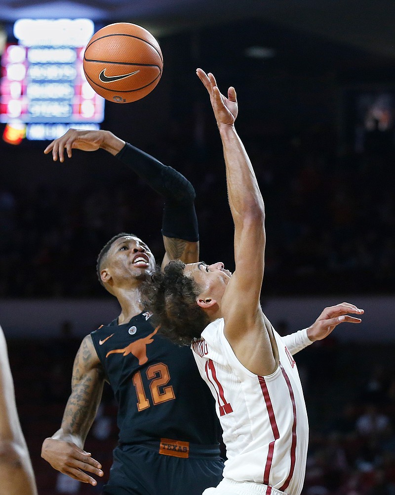 Texas guard Kerwin Roach II (12) knocks the ball away as Oklahoma guard Trae Young, right, shoots in the second half of an NCAA college basketball game in Norman, Okla., Saturday, Feb. 17, 2018. (AP Photo/Sue Ogrocki)