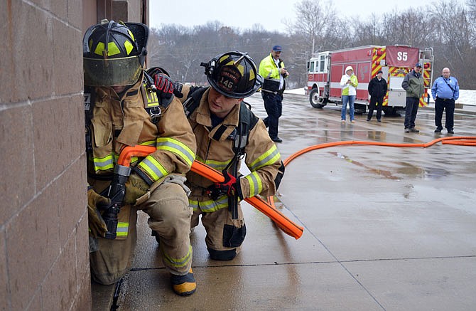 Matt Luebbert, right, a driver for the Jefferson City Fire Department, assists Staff Sgt. Eric Moenster in hose line advancement drills Saturday during fire training exercises at the department's Hyde Park Training Facility. The Veteran Firefighter Initiative is designed to get veterans interested in firefighting careers.
