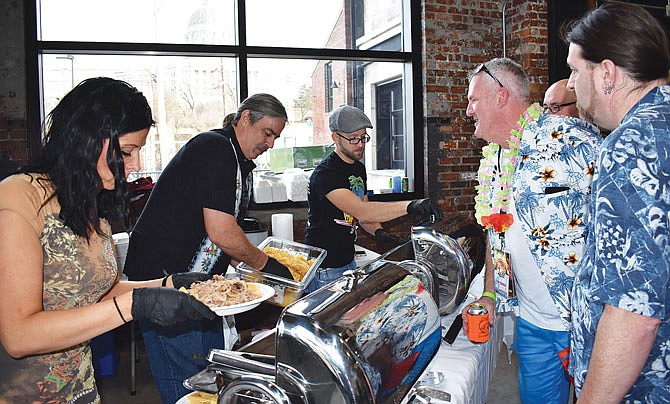 From left, Ashley Abbotte and JQ's restaurant owners, John Johnson and Quinten Rice, serve pulled pork nachos and sandwiches while chatting with Tim Tinnin, who started Angiepalooza, and John Breeden of the band Five Turn Knot. They were at The Millbottom on Sunday for Angiepalooza Winter Luau, a fundraiser for cancer patients. 