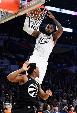 LeBron James dunks over Kyle Lowry during Sunday night's NBA All-Star Game in Los Angeles.