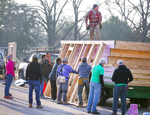 Volunteers and Habitat for Humanity workers cooperate to build the framing for their first "net zero" home for Steve and Elida Quiroz on Feb. 8 in East Austin, Texas. The "net zero" homes have solar panels and energy-efficient features that will mean little to no energy bill for the homeowners. (Ricardo Brazziell/Austin American-Statesman via AP)