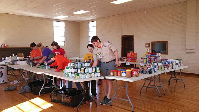 Boy Scouts and family members sort food after a past drive. Fundraising coordinator Scout Gibson said past years' takes have topped 4 tons.