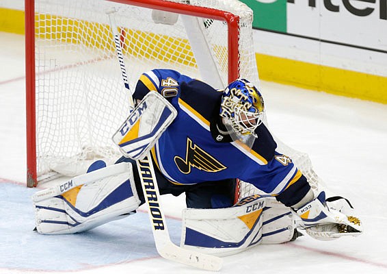 Blues goaltender Carter Hutton grabs the puck with his glove during Tuesday night's game against the Sharks in St. Louis.