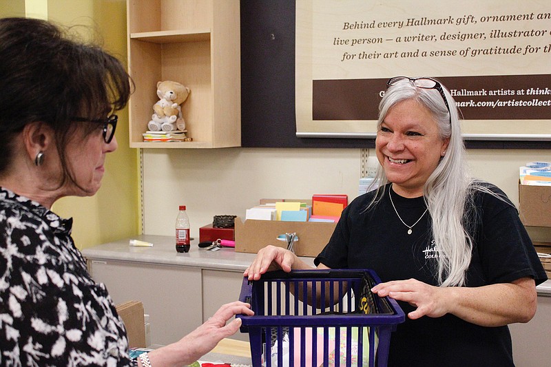 Sharon Wooten, Hallmark store general manager, talks with customer Johnie Smith on Monday at the store, 4278 St. Michael Drive. Hallmark is scheduled to close Feb. 28.