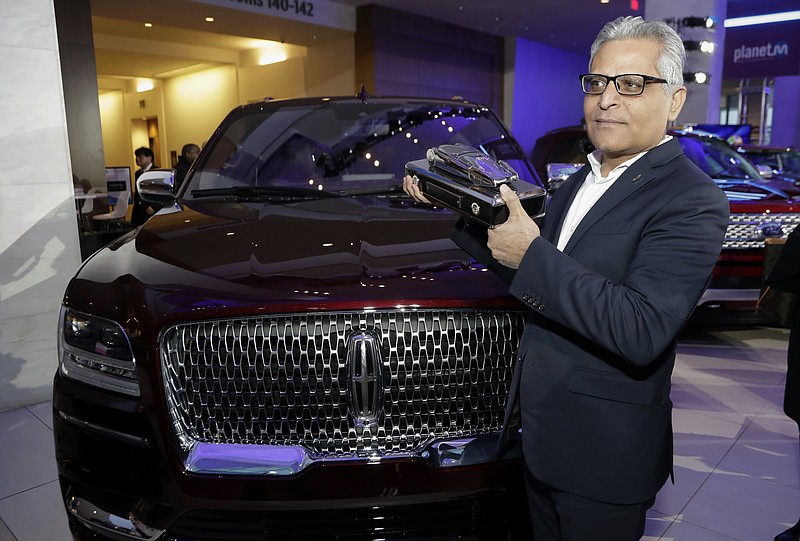 FILE- In this Jan. 15, 2018, file photo, Kumar Galhotra, group vice president for Lincoln stands next to the 2018 Lincoln Navigator after the vehicle won truck of the year during the North American International Auto Show in Detroit. Ford Motor Co. said Thursday, Feb. 22, that it is naming Galhotra as a replacement for Raj Nair, the president for North America who was ousted this week over allegations of inappropriate behavior. Galhotra will take over on March 1. (AP Photo/Carlos Osorio, File)