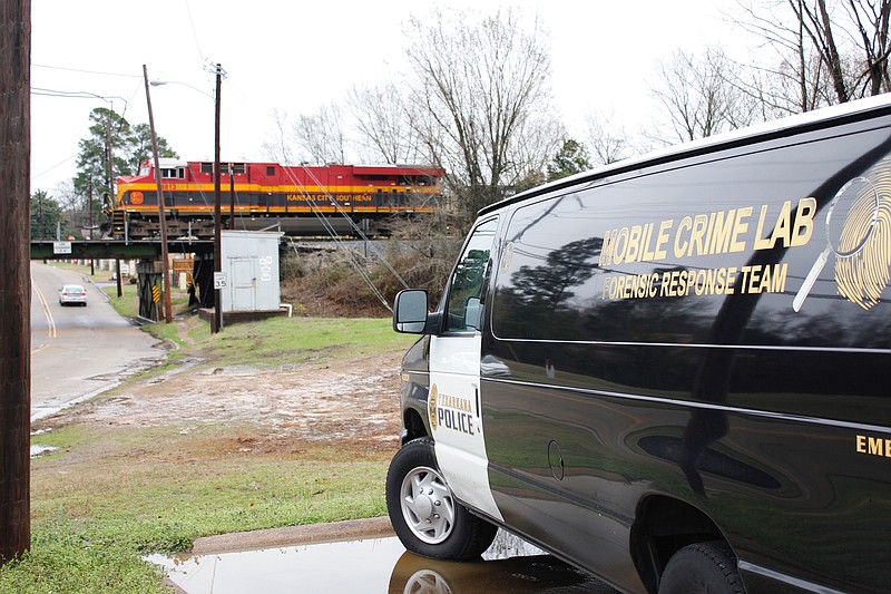 The Texarkana, Texas, Police Department mobile crime lab is seen close to where human remains where found in a tree Friday, Feb. 23, 2018, near the railroad tracks south of College Drive.