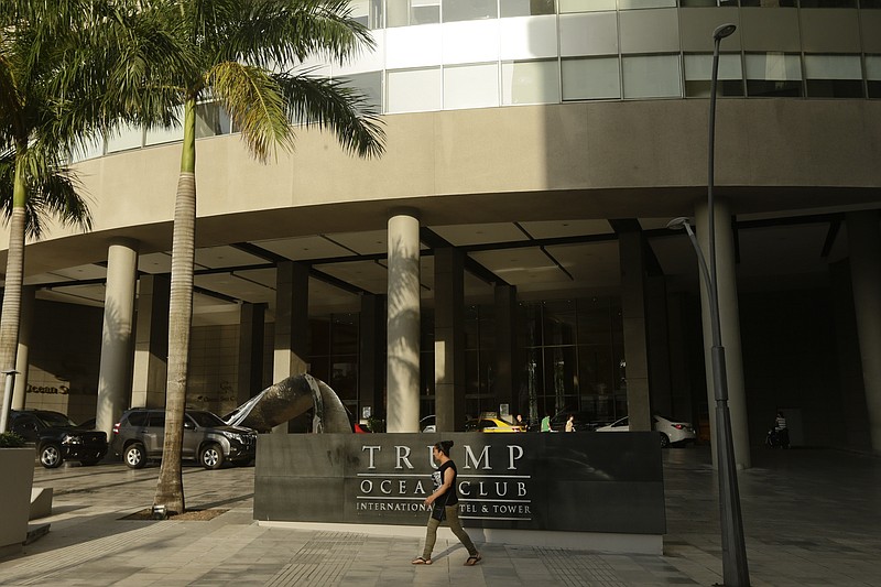 A woman past walks past the main entrance to the Trump Ocean Club International Hotel and Tower in Panama City, Friday, Feb. 23, 2018. One of President Donald Trump's family businesses is battling an effort to physically evict its team of executives from a luxury hotel in Panama where they manage operations, and police have been called to keep the peace, The Associated Press has learned. Witnesses told the AP they saw Trump's executives carrying files to a room for shredding. (AP Photo/Arnulfo Franco)