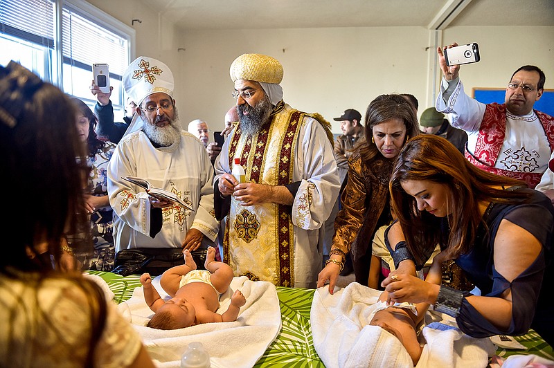In a Saturday, Feb. 3, 2018 photo, Father Girgis Ramandious, left, and His Grace Bishop Karas, center, pray over two newly baptized girls during the first Coptic Orthodox service in the old Trinity United Methodist building owned by Bethlehem UMC in Dallastown. After almost two years of worshipping in downtown York, the community of 80 Egyptian Coptic Christian families has found a new home for now, this time, in Dallastown, about seven miles down the road.  (Chris Dunn/York Daily Record via AP)