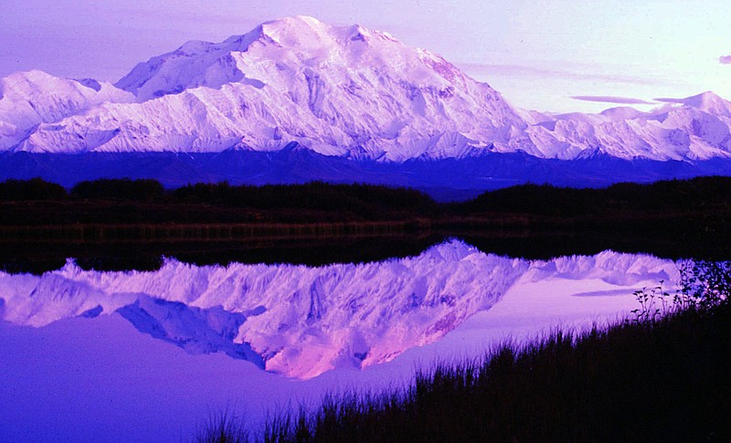 In this undated file photo, the sun sets as Mount McKinley casts its reflection on Reflection Pond at the west end of Denali National Park Road in Denali Park, Alaska. US Interior Department Secretary Ryan Zinke said Friday, Feb. 23, 2018, that he wants to reorganize the agency that oversees vast public lands and energy resources in the West. (AP Photo/Al Grillo, File)