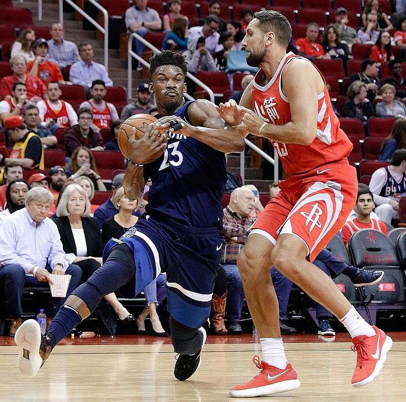 Minnesota Timberwolves guard Jimmy Butler (23) drives around Houston Rockets forward Ryan Anderson (33) during the first half of an NBA basketball game Friday, Feb. 23, 2018, in Houston. (AP Photo/Michael Wyke)