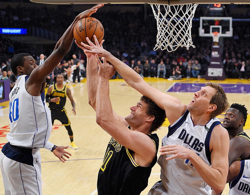 Dallas Mavericks forward Harrison Barnes, left, and forward Dirk Nowitzki, right, of Germany, block the shot of Los Angeles Lakers center Brook Lopez during the first half of an NBA basketball game Friday, Feb. 23, 2018, in Los Angeles. (AP Photo/Mark J. Terrill)