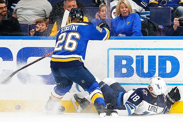 Paul Stastny of the Blues checks Bryan Little of the Jets off the puck during the first period of Friday night's game in St. Louis.