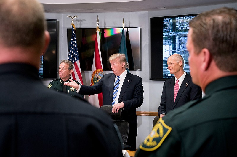 In this Feb. 16, 2018, photo, President Donald Trump, center, accompanied by Broward County Sheriff Scott Israel, left, and Florida Gov. Rick Scott, right, speaks as they meet with law enforcement officers at Broward County Sheriff's Office in Pompano Beach, Fla., following the shooting at Marjory Stoneman Douglas High School, in Parkland, Fla. Once again, it was the images of children that propelled Trump to act. Trump spent the first days after the Valentine's Day school shooting that left 17 dead fixated on the traumatized students and parents spilling out their grief and anguish in Parkland, Florida. (AP Photo/Andrew Harnik)