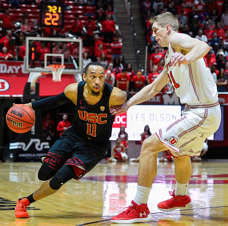 USC guard Jordan McLaughlin (11) attempts to drive past Utah forward Tyler Rawson (21) during the first half of an NCAA basketball game on Saturday, Feb. 24, 2018, in Salt Lake City. (AP Photo/Alex Goodlett)