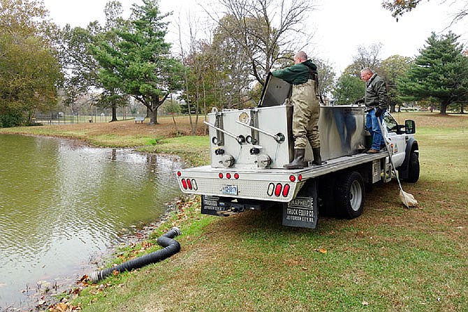 Dillon Howe, left, resource assistant from the Montauk State Fish Hatchery near Licking, and Scott J. Voney, a Missouri Department of Conservation fisheries biologist from Columbia, stocked 800 rainbow trout last fall at Veterans Park Lake in Fulton. 