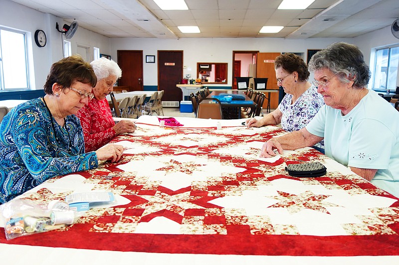 <p>Helen Wilbers/FULTON SUN</p><p>Elaine Richards, left, Evalane Meyer, Helen Martin and Betty Crawford stitch away at a quilt. Each year, the Barkersville Quilting Club’s work is raffled off at Tebbetts’ Fourth of July picnic.</p>