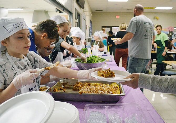 Young chefs from the Callaway Hills Elementary School Cooking Club serve lasagna with all the fixings Wednesday during a fundraising dinner for family and friends. The money raised will go to the school's cooking and the garden clubs.