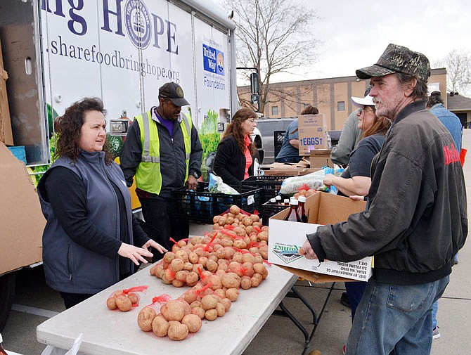 The Food Bank for Central and Northeast Missouri's mobile food pantry was open for business Wednesday at St. Martins Catholic Church as Shelley Wright fills a box of food for Mike McMillan.