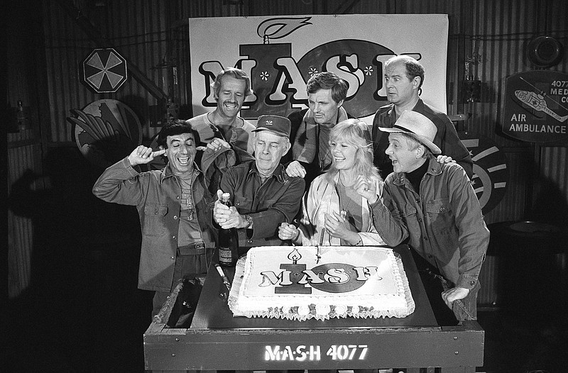 FILE - In this Oct. 22, 1981, file photo, Jamie Farr, from front left, plugs his ears as cast members of the "M.A.S.H." television series cast Harry Morgan, Loretta Swit, William Christopher and, from back from left, Mike Farrell, Alan Alda and David Ogden Stiers celebrate during a party on the set of the popular CBS program in Los Angeles. Stiers a prolific actor best known for playing a surgeon on the television series "M.A.S.H." has died, the actor's agent Mitchell Stubbs confirmed Saturday night, March 4, 2018, in an email. He was 75. (AP Photo/Huynh, File)