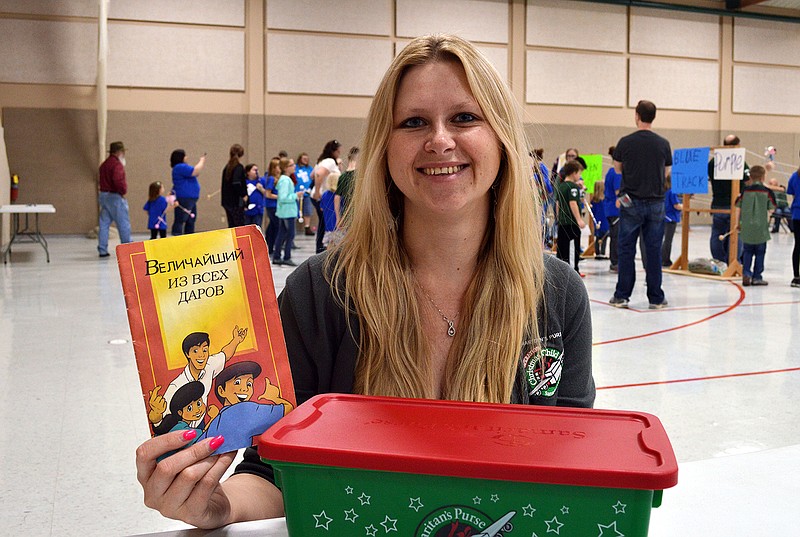 Elena Hagemeier, of the former Soviet Union, spoke to American Heritage Girls on Saturday, March 3, 3018, at the Capital City Christian West Event Center in Jefferson City about the impact of a "shoebox gift" from Operation Christmas Child that she received when she was young and in an orphanage. Prior to speaking she showed some of the contents of a current shoebox including a booklet titled "The Greatest Gift" printed in multiple languages, including the Russian shown here.