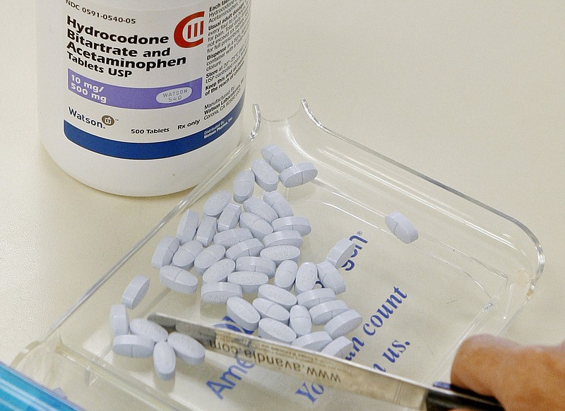 In this Aug. 5, 2010, file photo, a pharmacy technician poses for a picture with hydrocodone and acetaminophen tablets, also known as Vicodin, at the Oklahoma Hospital Discount Pharmacy in Edmond, Okla. Opioids including Vicodin and fentanyl patches worked no better than Tylenol and other over-the-counter pills at relieving chronic back pain and hip and knee arthritis in a year-long study of mostly men at Minneapolis VA clinics. Both groups had slight improvement. (AP Photo/Sue Ogrocki, File)