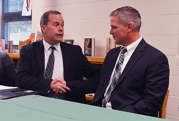 Blair Oaks superintendent Dr. Jim Jones (left) shakes hands Tuesday with Ted LePage after announcing LePage would be the new head football coach of the Falcons at a press conference in Wardsville.