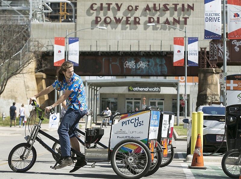 Austin Pedicab driver Rob Cross parks his electric-assisted vehicle on Tuesday, March 6, 2018 in Austin, Texas.  Some Austin pedicabs are getting a boost just in time for the spring festival season by installing electric motors as part of a new city pilot program.  Austin Transportation Department and Austin Energy have teamed up for the yearlong pilot to see how electric pedicabs perform in the city before potentially going to the City Council to shape an ordinance making them a permanent feature.   (Ralph Barrera/Austin American-Statesman via AP)
