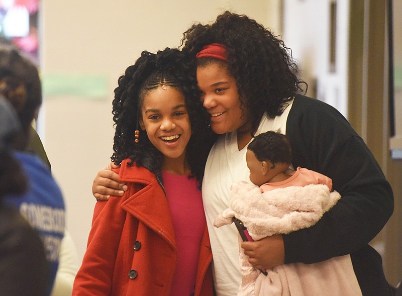Breyanna McNeese, 11, right, receives a hug from her sister Brandy McNeese, 12, Friday after she won first place in the Boys & Girls Club Black History Month Portrait contest at the Boys & Girls Club.