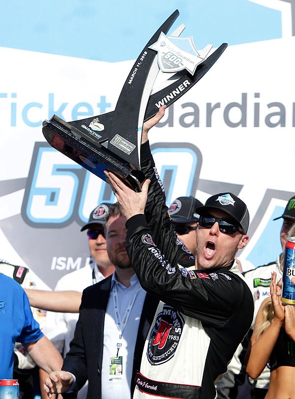 Kevin Harvick holds up the trophy after winning Sunday's NASCAR Cup Series race in Avondale, Ariz.
