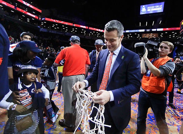 Virginia coach Tony Bennett walks off the floor with one of the nets after Virginia defeated North Carolina 71-63 in Saturday's Atlantic Coast Conference Tournament championship game in New York.