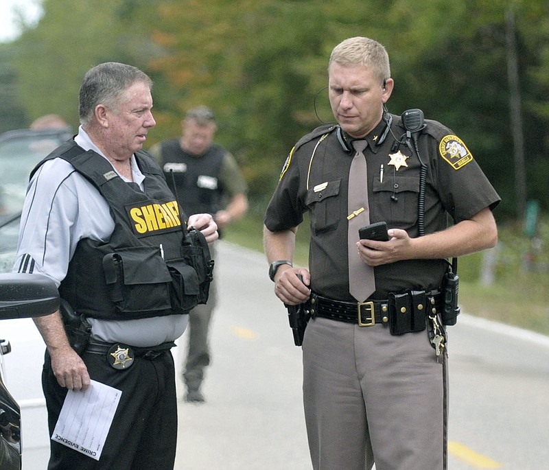 In this Sept. 27, 2017 photo, Isabella County Sheriff Michael Main, right, coordinates efforts in a police manhunt in rural Isabella County, Mich. Main is apologizing for accidentally leaving his gun in a mid-Michigan school gym locker room. Main said Tuesday, March 13, 2018 he takes full responsibility and is "devastated" by his own negligence. He says he was at a weekend event at Shepherd Middle School and used the locker room to change into uniform. (Lisa Yanick Litwiller /The Morning Sun via AP)