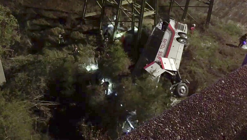 This photo provided by Jesus Tejada shows first responders searching around a bus that plunged into a ravine, Tuesday, March 13, 2018 on Interstate 10, Loxley, Ala. Several people were on board, and all of them were brought to 10 hospitals in Alabama and Florida, either by helicopter or ambulance, said Baldwin County Sheriff Huey Hoss Mack. (Jesus Tejada)