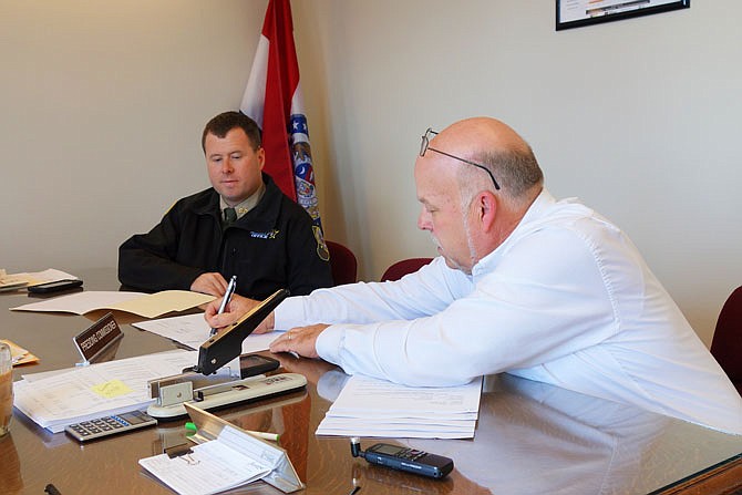 Presiding County Commissioner Gary Jungermann, right, signs a contract authorizing a school resource officer for South Callaway R-2. According to Callaway County Sheriff Clay Chism, left, this plan has been in the works since last year.