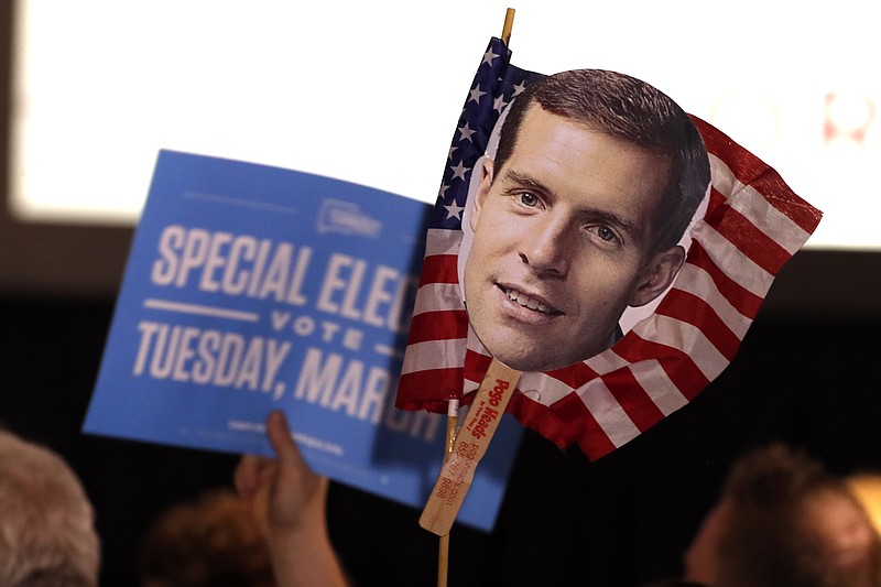 Supporters of Conor Lamb, the Democratic candidate for the March 13 special election in Pennsylvania's 18th Congressional District hold signs during his election night party in Canonsburg, Pa., Wednesday, March 14, 2018. Rattled Republicans were hit with the reality check Wednesday in the startling strong performance of a fresh-faced Democrat deep in Trump country. (AP Photo/Gene J. Puskar)