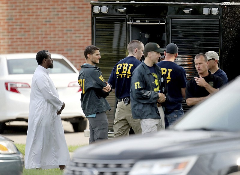 FILE - In this Aug. 15, 2017 file photo, Law enforcement officials investigate an explosion at the Dar Al-Farooq Islamic Center in Bloomington, Minn. Federal authorities said Tuesday, March 13, 2018, they have charged three men from rural central Illinois with the bombing of a Minnesota mosque last year and one of the men told an investigator the goal of the attack was to "scare" Muslims out of the United States. A statement from the U.S. attorney's office in Springfield, Illinois, says the men also are suspected in the attempted bombing of an abortion clinic in November. (David Joles/Star Tribune via AP File)