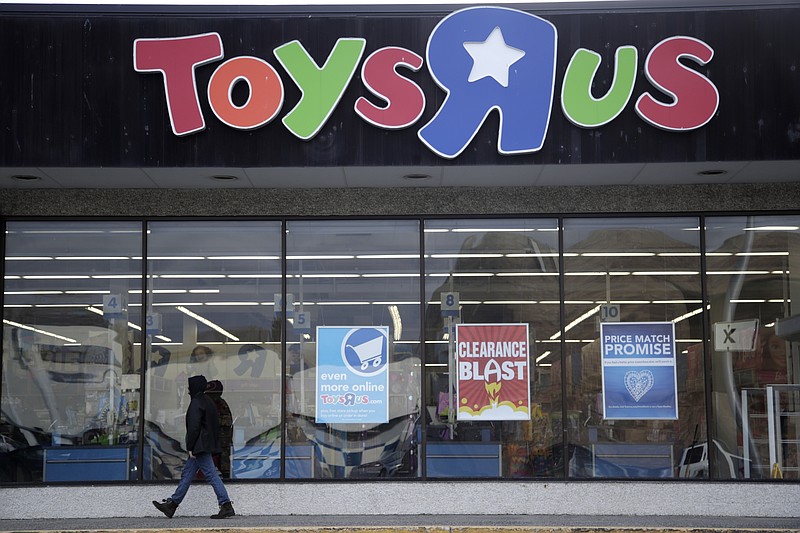 File- This Jan. 24, 2018, file photo shows a person walking near the entrance to a Toys R Us store, in Wayne, N.J.  Toys R Us's management has told its employees that it will sell or close all of its U.S. stores. That's according to a toy industry analyst who spoke to several employees who were on the call Wednesday, March 14, 2018. Jim Silver, a toy industry expert, says Toys R Us's CEO told employees the plan is to liquidate all of its U.S. stores and after that, it could do a deal with its Canadian operation to run some of its U.S. stores. The company declined to comment. (AP Photo/Julio Cortez, File)