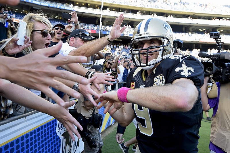 In this Oct. 2, 2016, file photo, New Orleans Saints quarterback Drew Brees reacts with fans after an NFL football game against the San Diego Chargers, in San Diego. A person familiar with the contract says Drew Brees has agreed to a two-year, $50 million extension with the New Orleans Saints. The person spoke to The Associated Press on condition of anonymity on Tuesday, March 13, 2018, because the agreement has not been announced. (AP Photo/Denis Poroy, File)